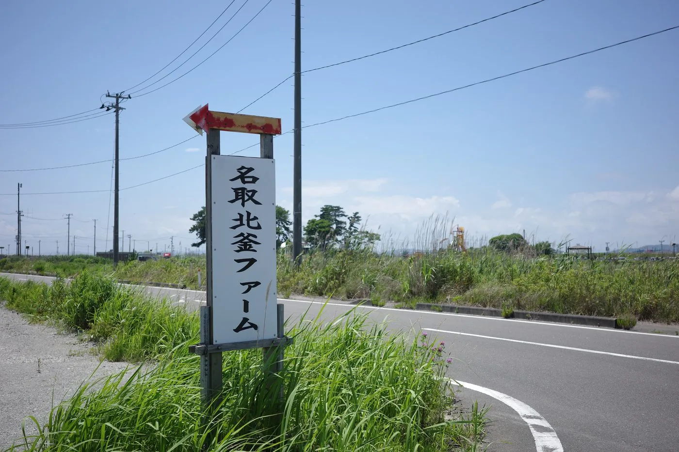 北釜地区の道路沿いに立つ名取北釜ファームの案内看板